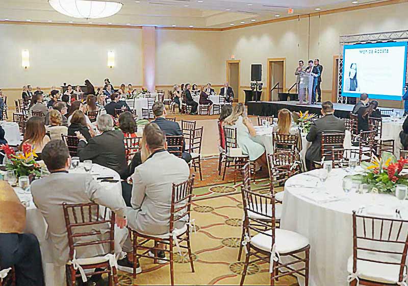 A banquet full of people listening to a speaker.